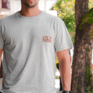 Tienda Handsome man in a gray t-shirt standing outdoors on a sunny day, embodying a casual lifestyle.